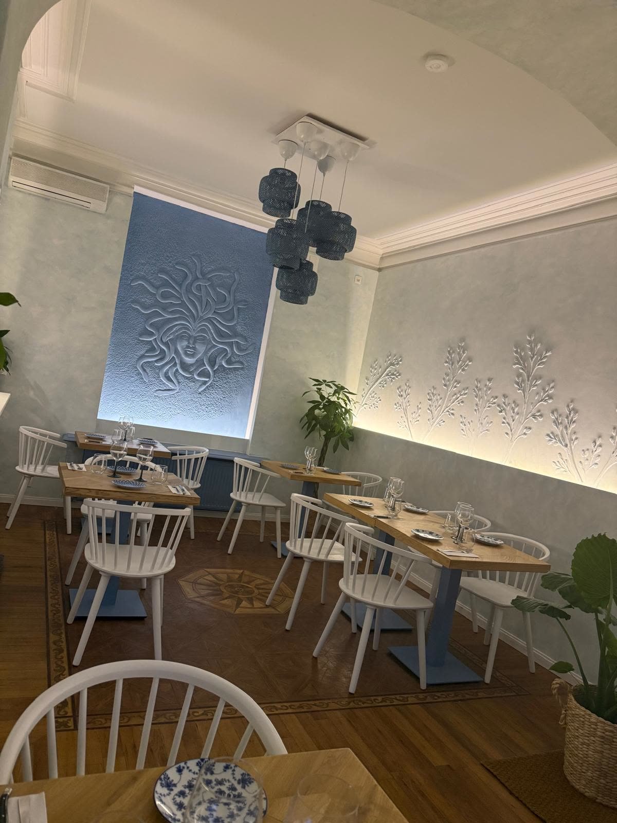 Salle intérieure du restaurant grec MEDUSA à Zaventem, décor méditerranéen et fresque murale de Méduse
